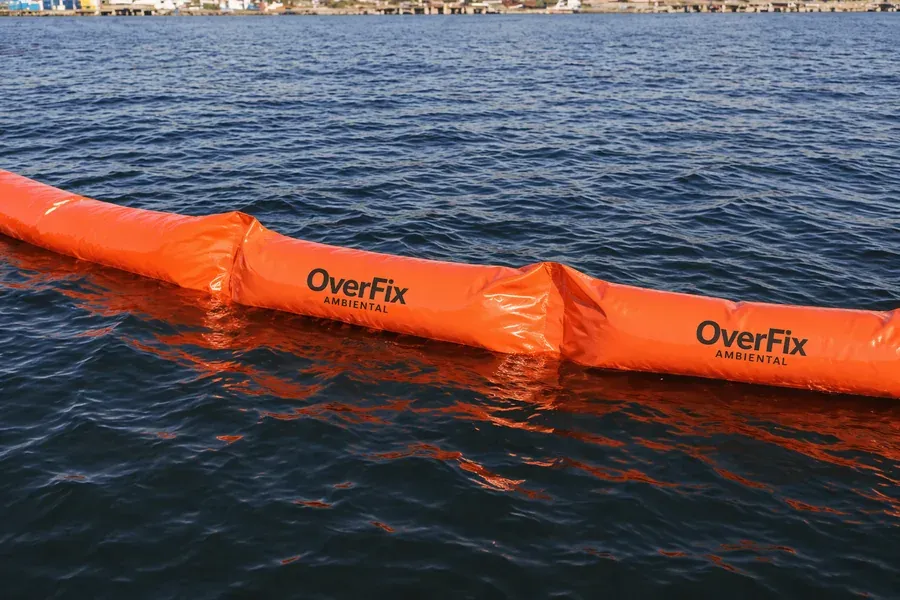 Barreira de contenção laranja estendida em mar aberto