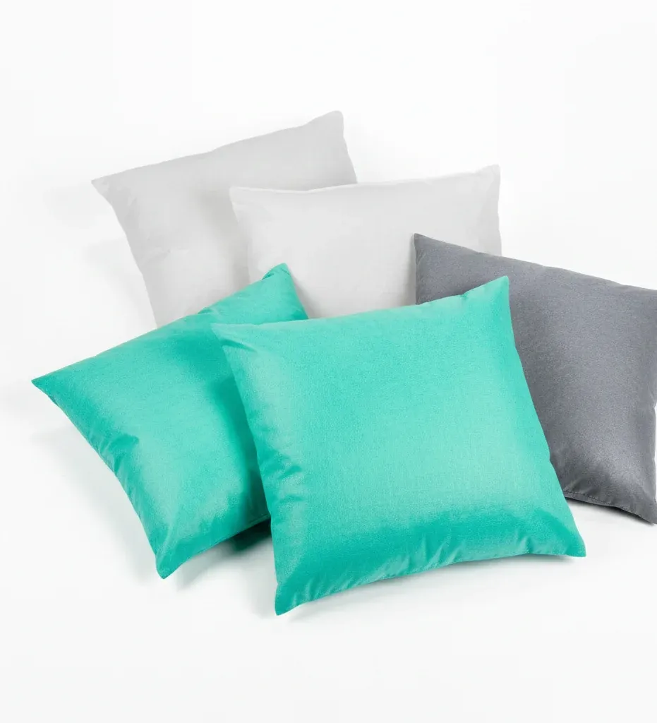 Travesseiros absorventes das três linhas agrupados, os dois verdes à frente e os brancos e cinza atrás