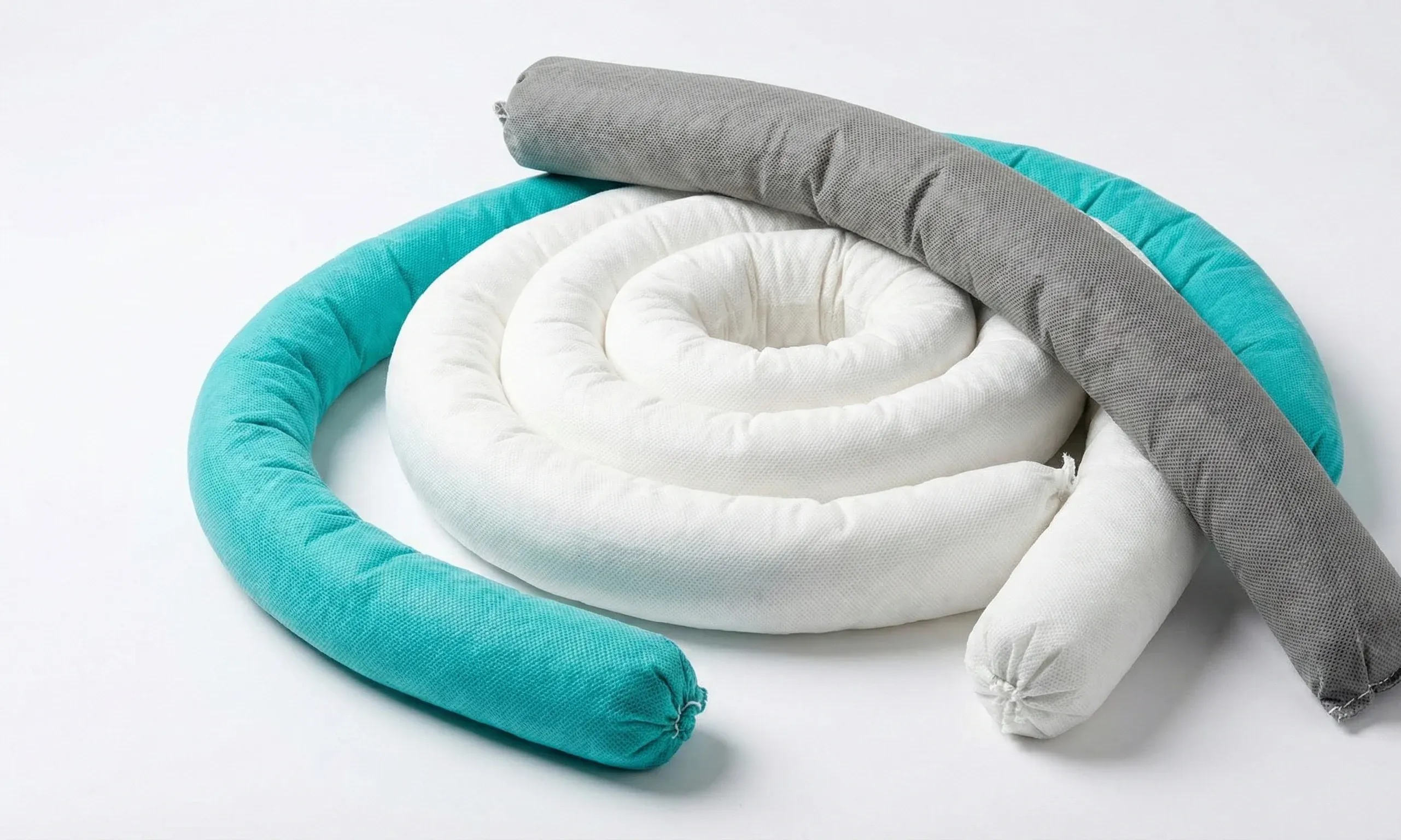 Cordões absorventes das três linhas: o branco enrolado em espiral, com o verde e o cinza estendidos por cima